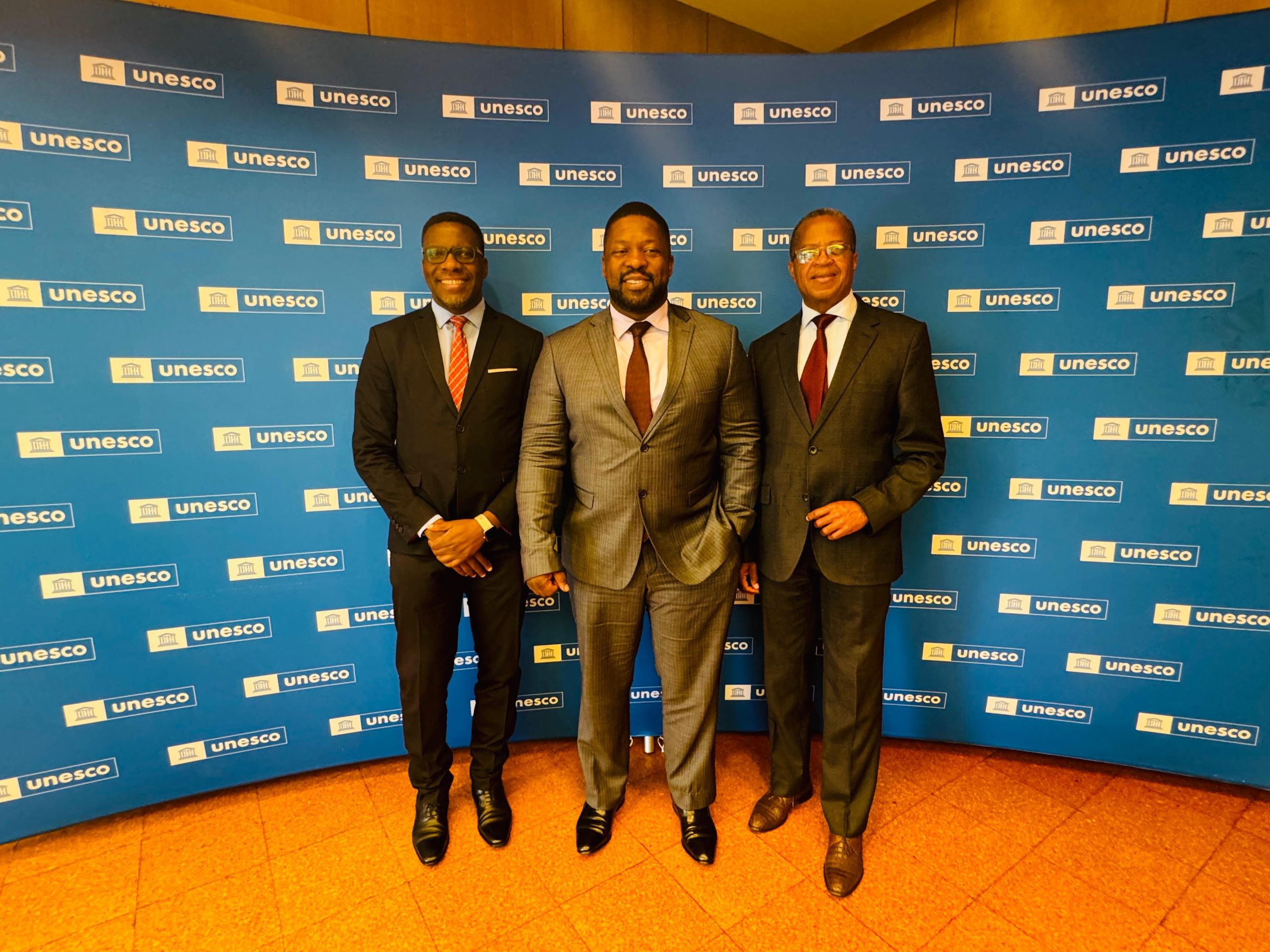 Three men standing behind a blue background